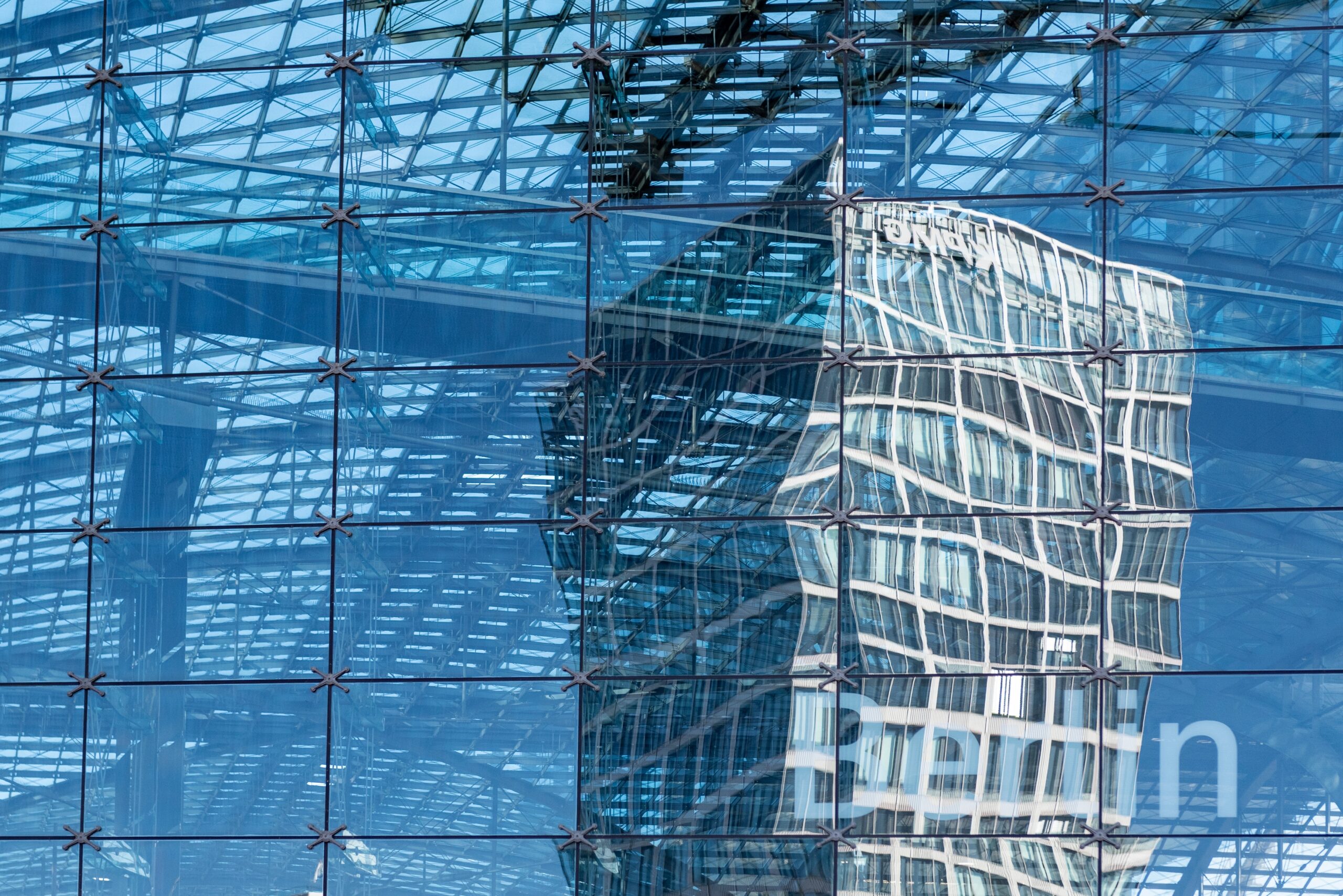 Hoofdingang van een treinstation gefotografeerd door glas