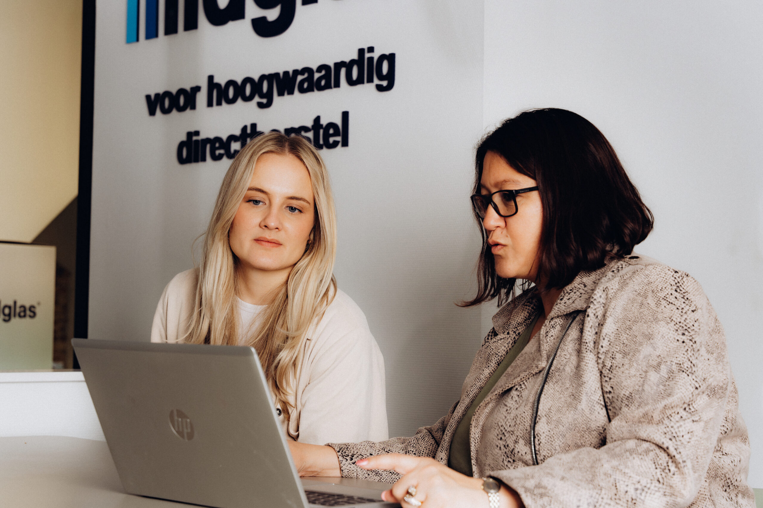 Collega's die samen op een laptop aan het werk zijn