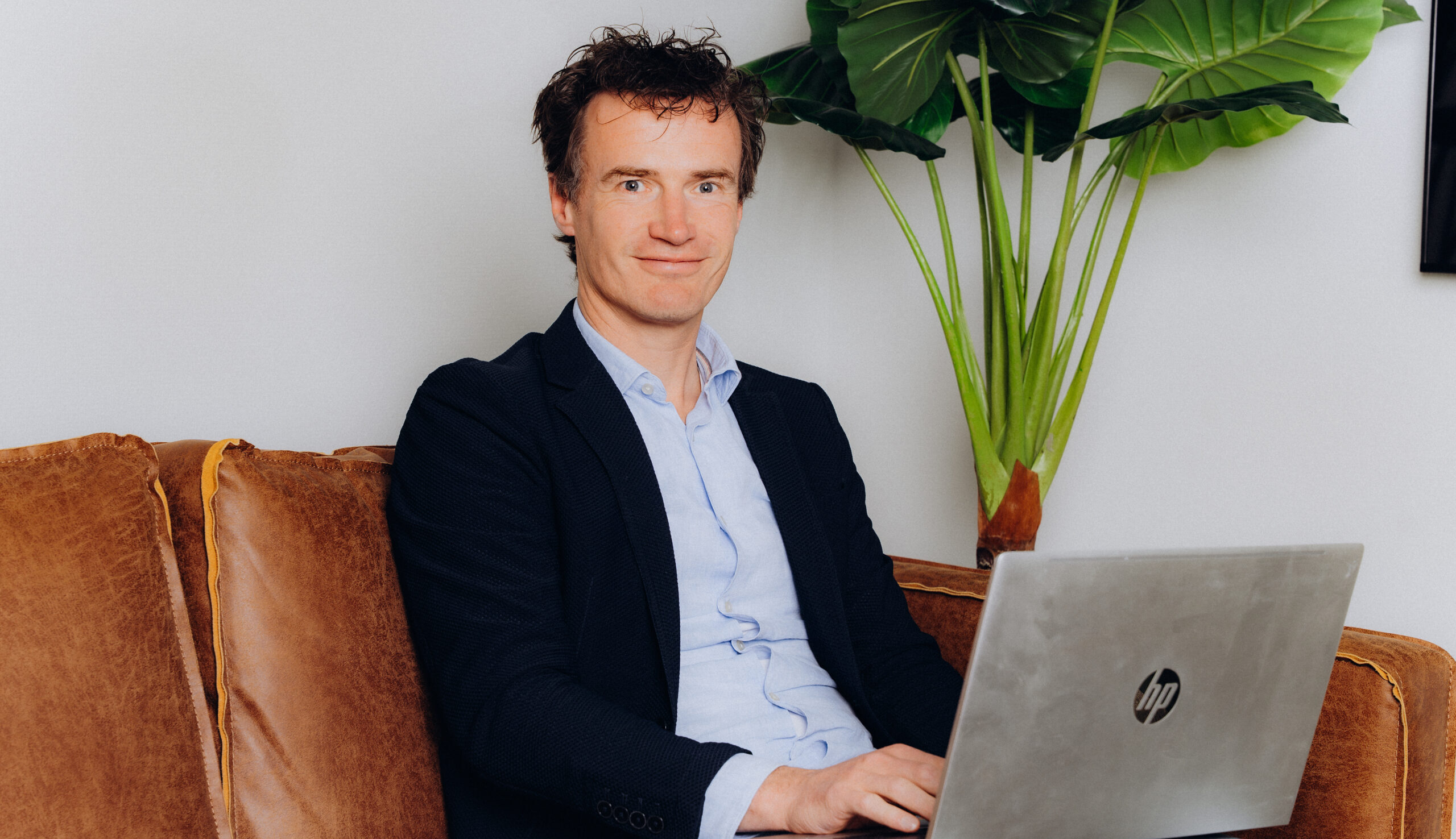 Collega van Midglas werkend achter zijn laptop